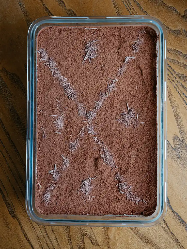 Tray of house-made tiramisu dusted with cocoa and shaved chocolate for catering